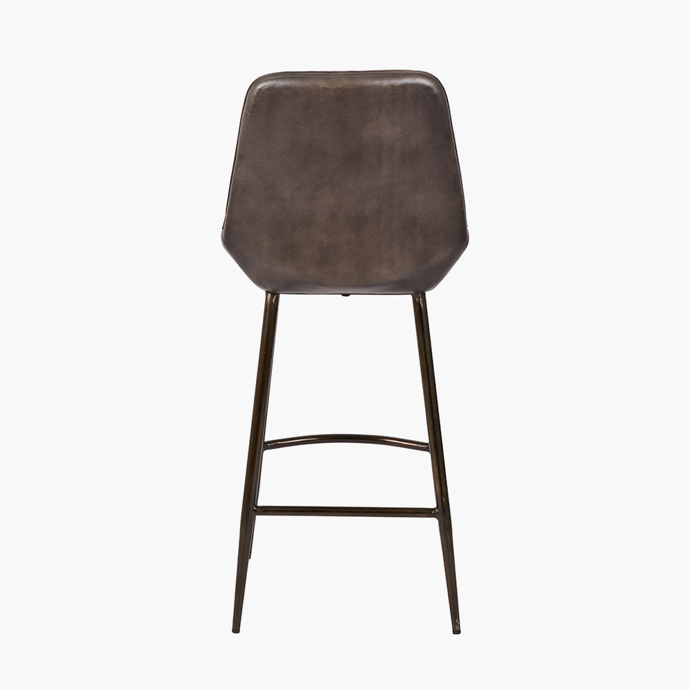 Upholstered in deep peppercorn-toned leather with ribbed cushioning and bronze metal frame, this handcrafted bar stool offers both comfort and visual impact. Shop online today at www.nobleandnook.co.uk