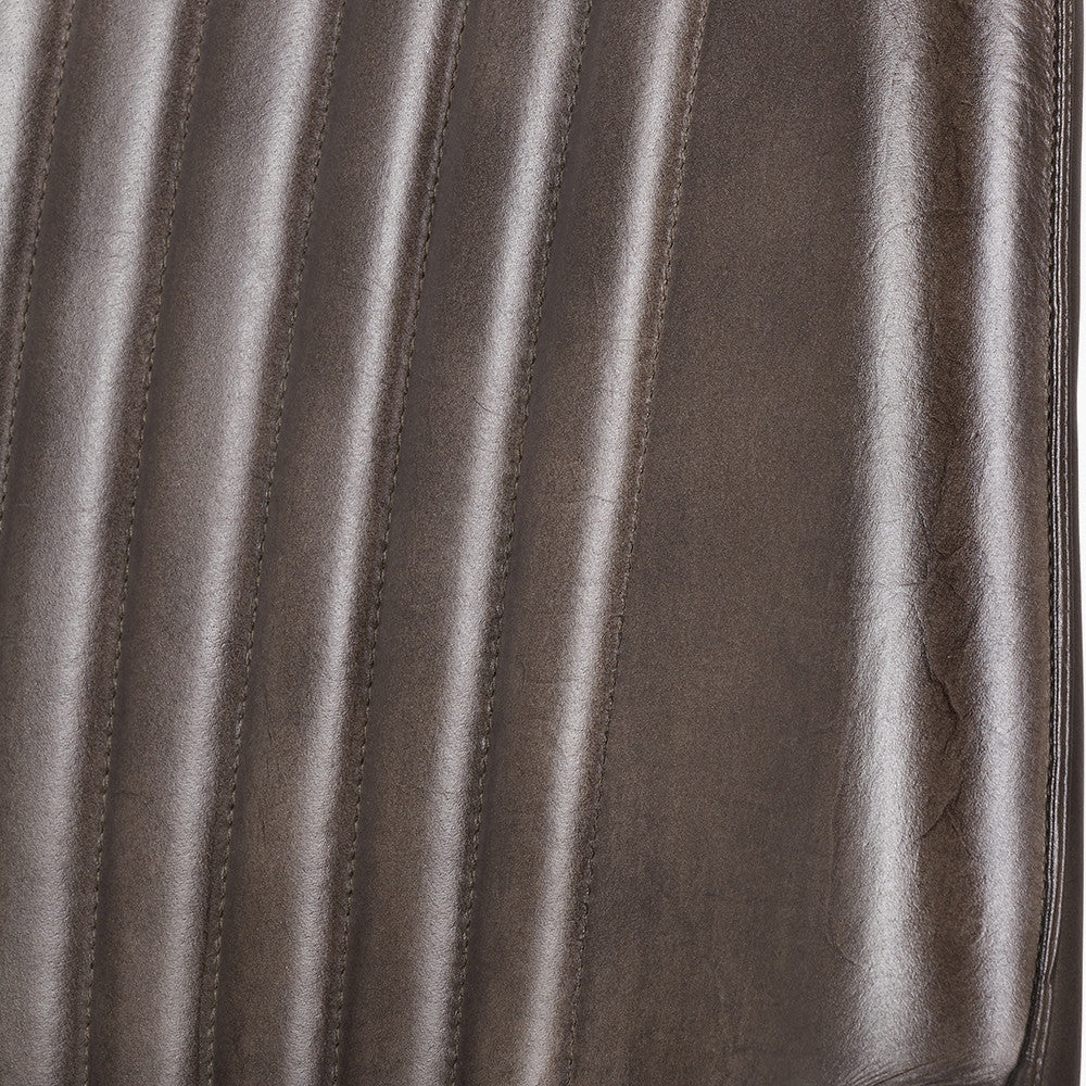 Upholstered in deep peppercorn-toned leather with ribbed cushioning and bronze metal frame, this handcrafted bar stool offers both comfort and visual impact. Shop online today at www.nobleandnook.co.uk