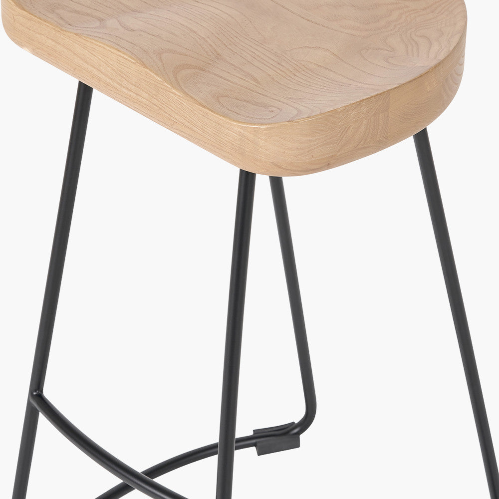 Enhance your seating area with this minimalist bar stool featuring a solid ash wood seat paired with black metal legs, creating a striking contrast that suits contemporary interiors. Shop online today at www.nobleandnook.co.uk