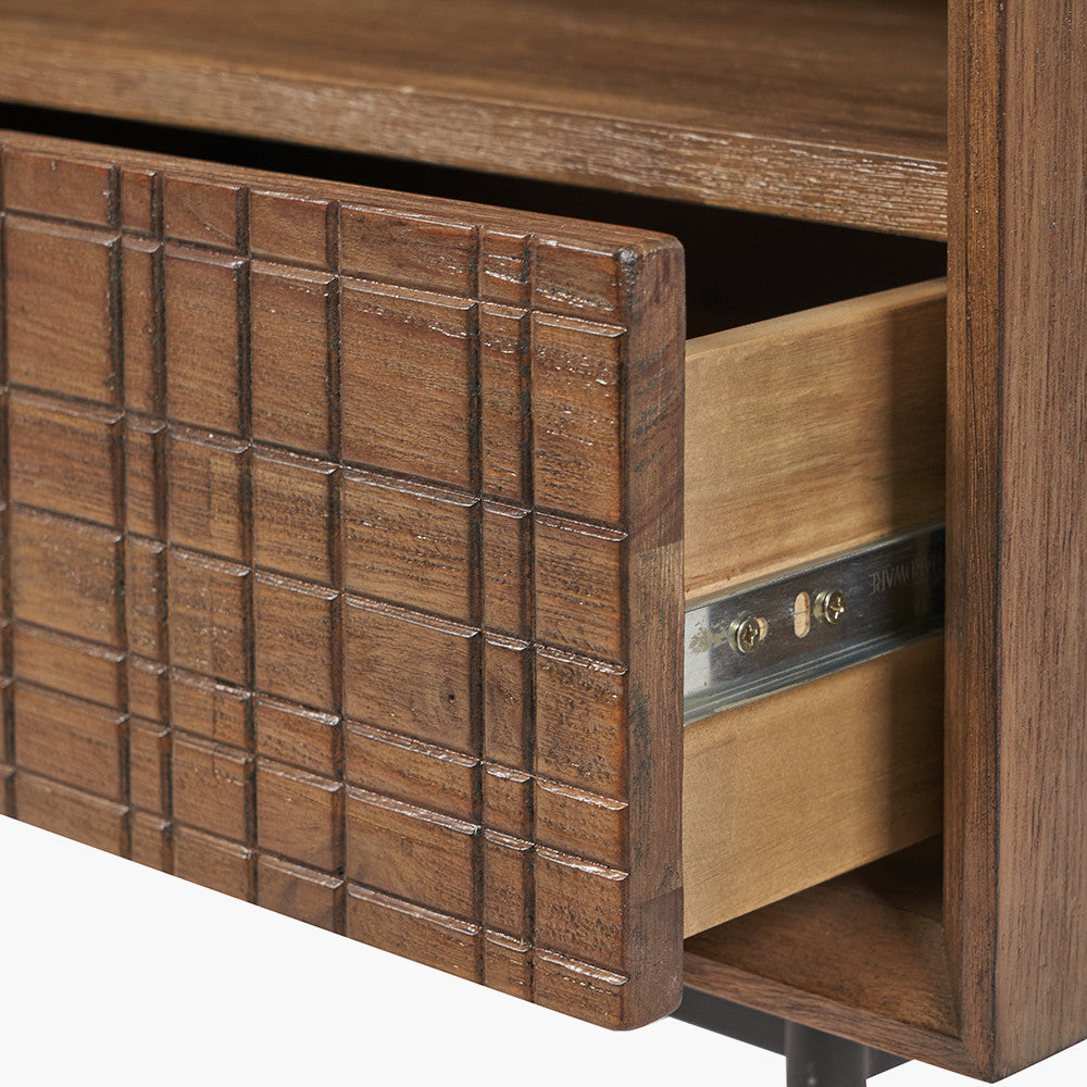 Shop the Arte Bedside Unit in dark brown acacia wood with etched detailing and sleek black metal legs, one drawer and open niche offer ample storage for essentials. Shop online today at www.nobleandnook.co.uk