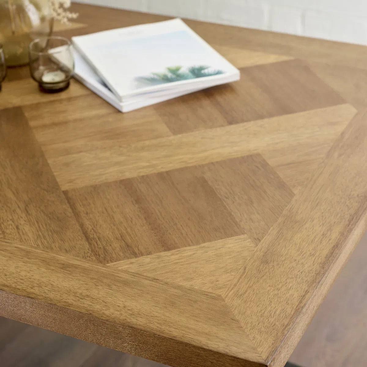 Shop the Aron Dining Table with eye-catching herringbone wood top with striking black metal base ensures lasting stability. Perfect for hosting dinners or enjoying everyday meals in style. Shop online at www.nobleandnook.co.uk