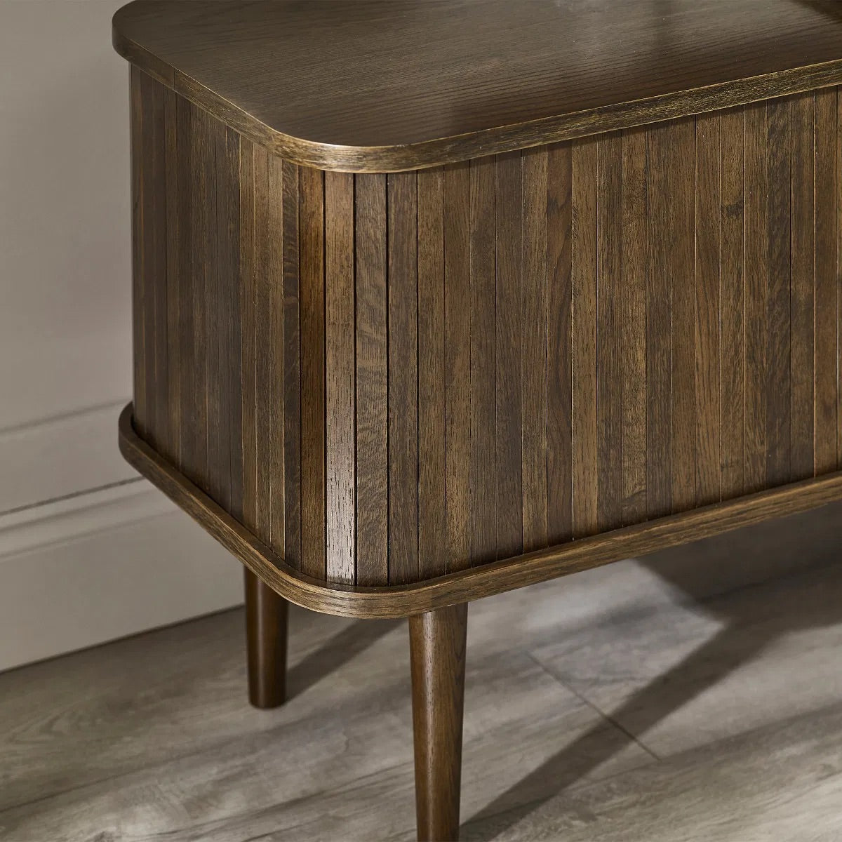 Elevate your living room with the Arya TV Media Unit in refined dark oak effect finish with sliding slatted doors. Perfect for modern homes. Shop online today at www.nobleandnook.co.uk