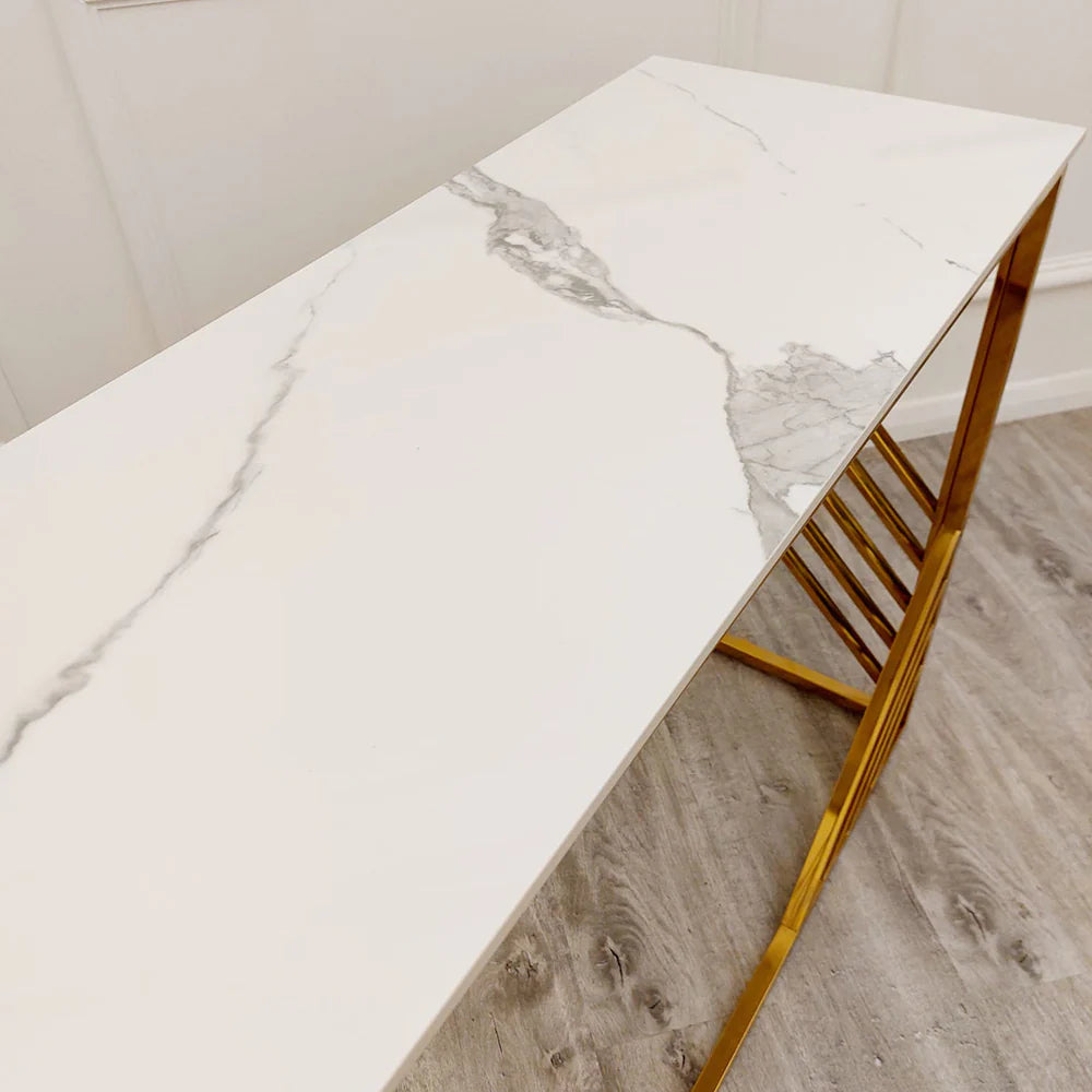 Shop now to redefine your interior design with the Azure Console Table. Featuring a gold tone frame with a Polar White Sintered Stone top. Perfectly suited for entrances and hallways. Shop online today at www.nobleandnook.co.uk