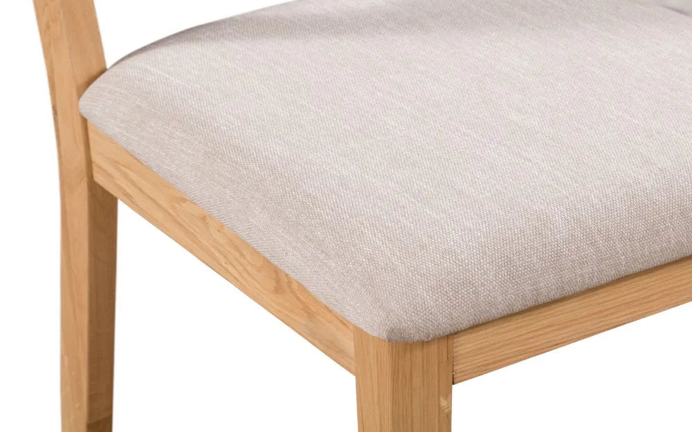 Enhance your dining space with the Elara Dining Chair, expertly crafted from solid oak for a blend of durability and natural beauty. Shop online today at www.nobleandnook.co.uk