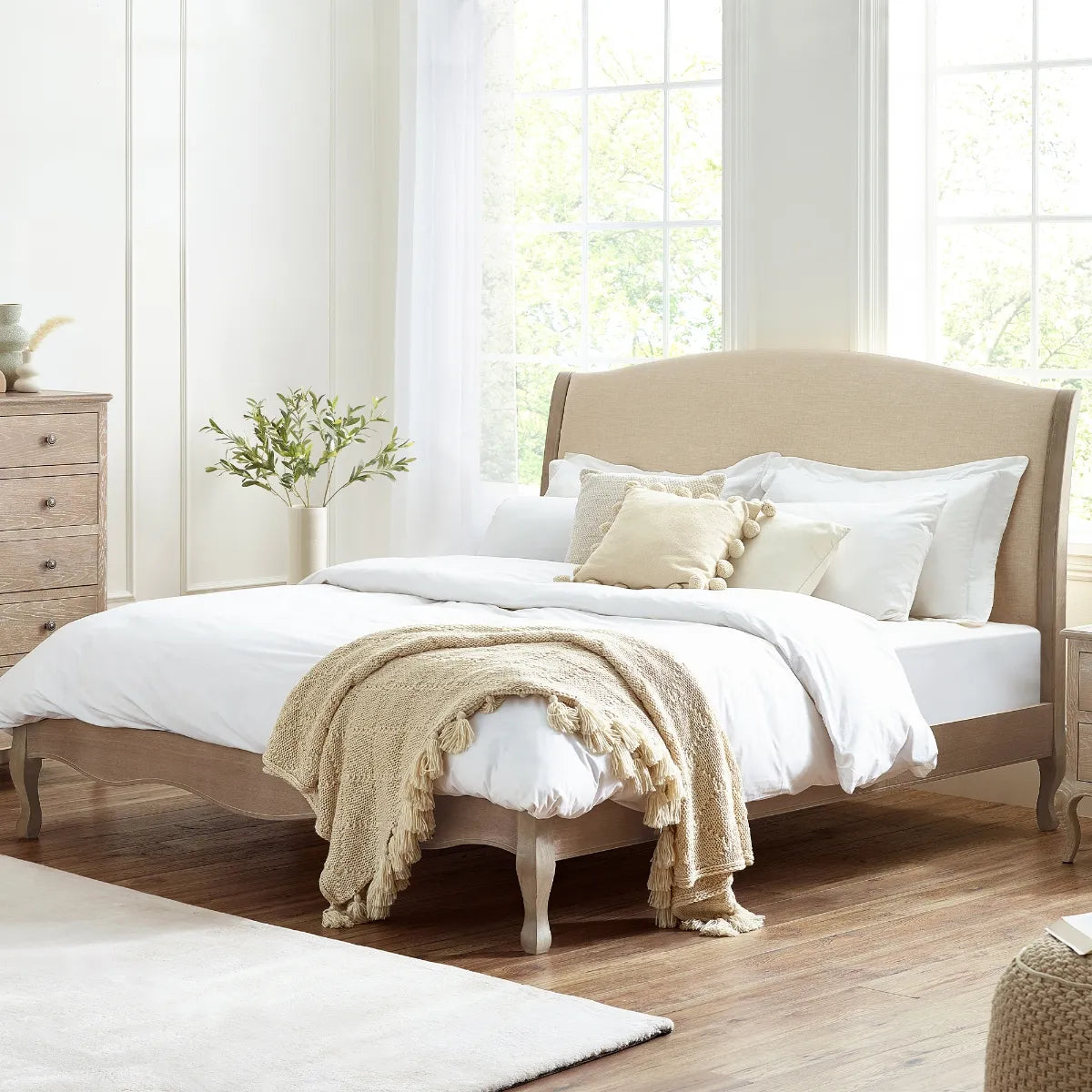 Shop a classic French design. The frame is finished in a limed oak effect, a soft upholstered headboard covered in an oatmeal linen fabric. Shop online today at www.nobleandnook.co.uk