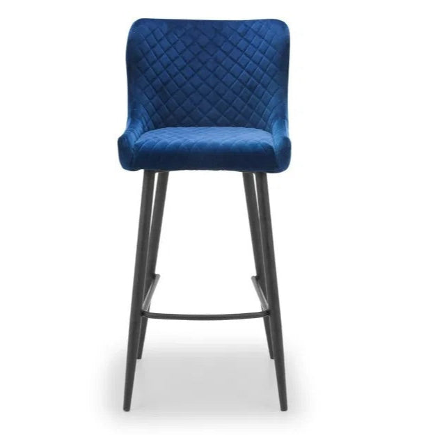 Bring a touch of luxury to your dining space with the Luxe Blue Velvet Bar Stool with sleek black metal legs. Ideal for kitchen islands, home bars, or high counters. Shop online today at www.nobleandnook.co.uk