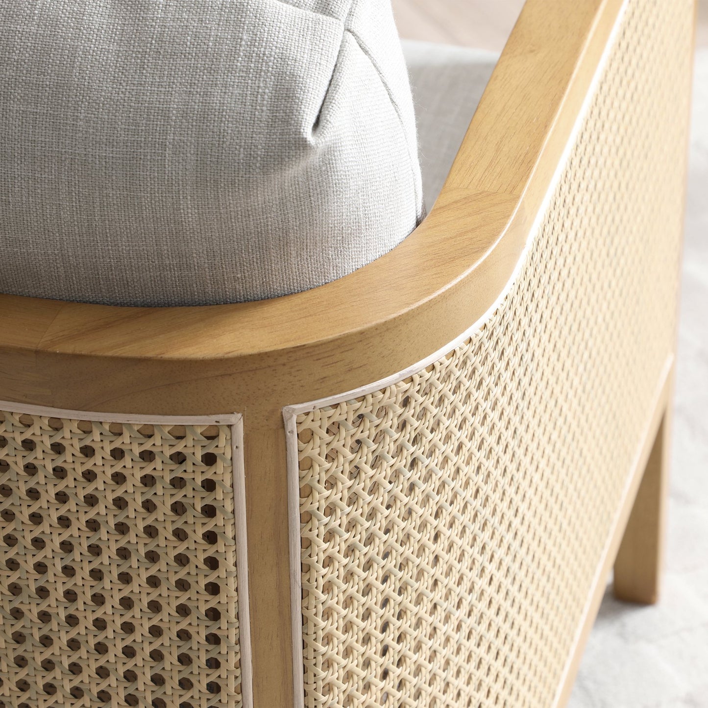 Shop the Mabel Rattan Accent Chair, a unique piece featuring a padded back and seat adorned with a bolster cushion, all resting on a stained wooden frame. Shop online now at www.nobleandnook.co.uk