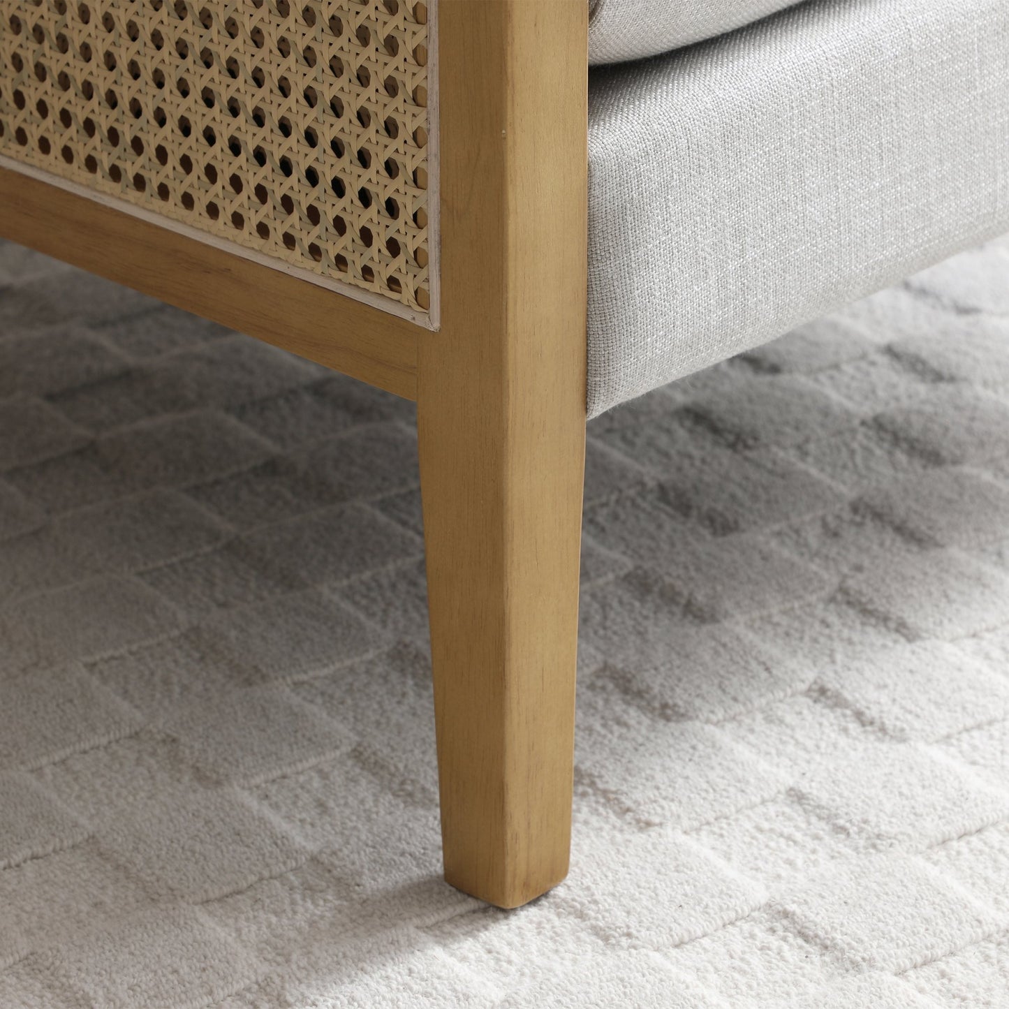 Shop the Mabel Rattan Accent Chair, a unique piece featuring a padded back and seat adorned with a bolster cushion, all resting on a stained wooden frame. Shop online now at www.nobleandnook.co.uk