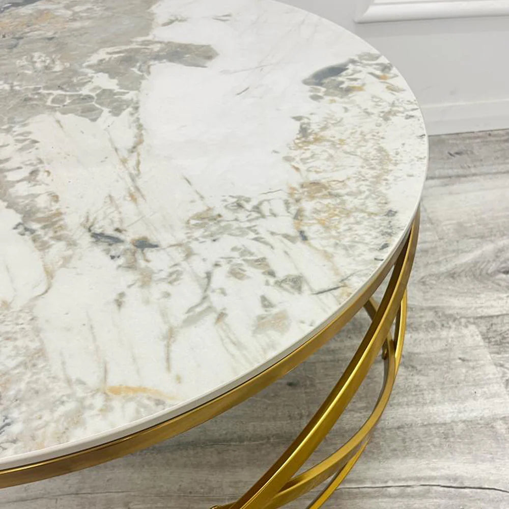Adding a touch of modern luxury to your living space, the Spiro Round Coffee Table features a sleek design with a Pandora sintered stone top and an intricate gold metal frame. Shop online today at www.nobleandnook.co.uk