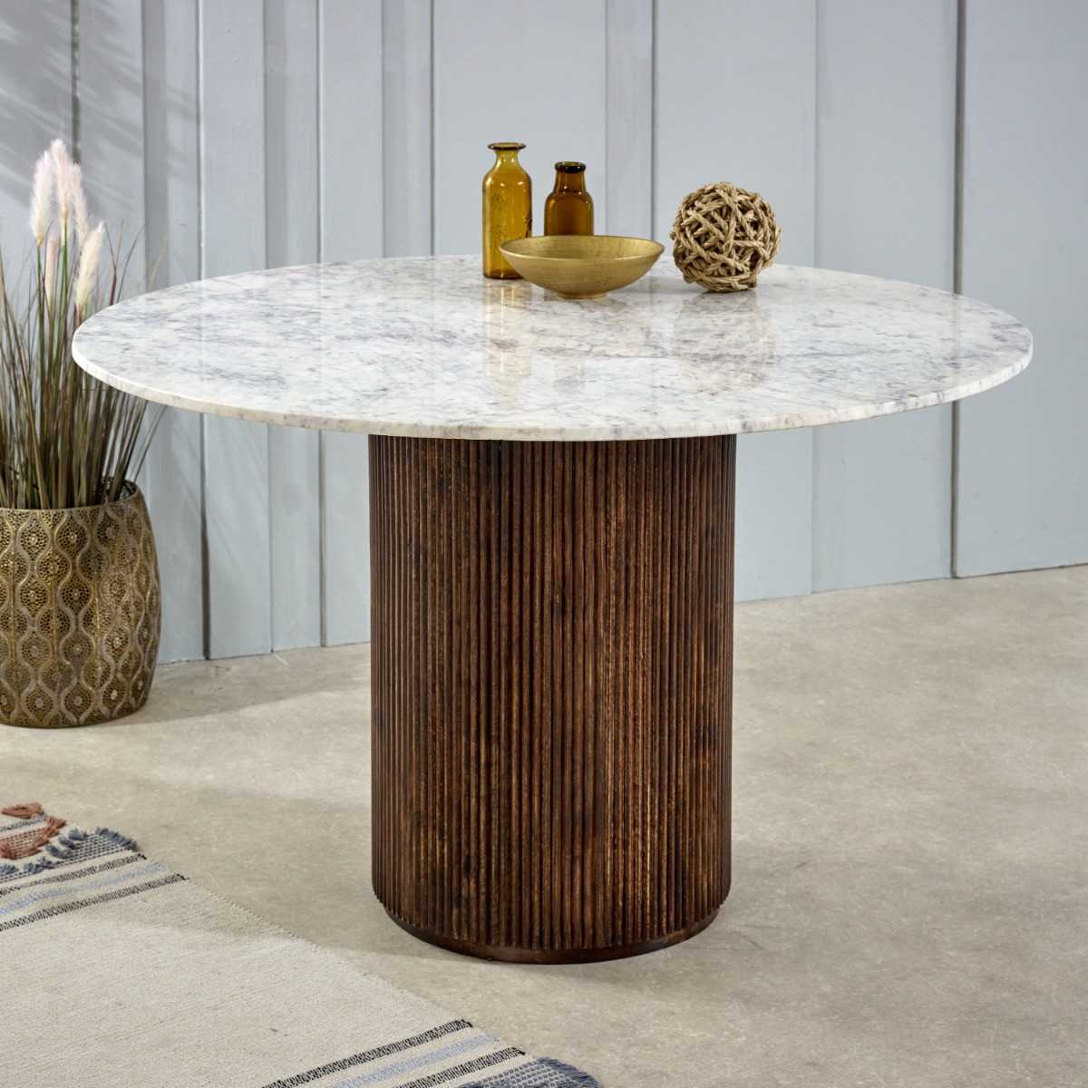 Luxurious white marble top with a sculptural base crafted from 100% solid mango wood for textural depth. Handmade in India using eco-friendly materials. H76×W120×D120cm. www.nobleandnook.co.uk