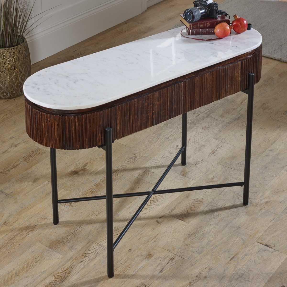 The handmade Opal Console Table with smooth marble top nests within a beautifully fluted mango wood frame, all supported by refined metal legs. H77×W120×D40 cm. Shop online today at www.nobleandnook.co.uk