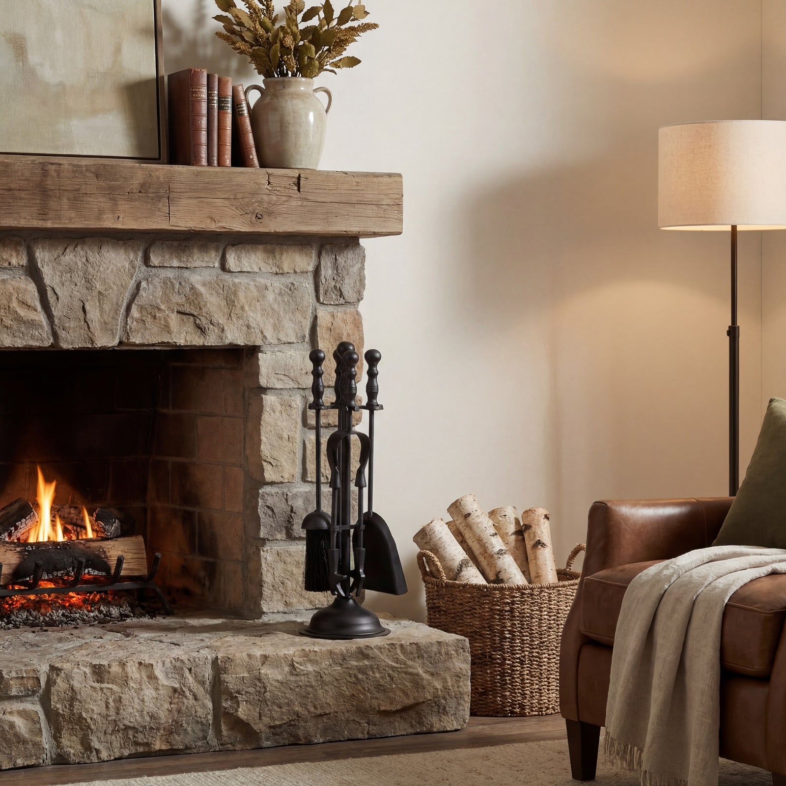 Cozy living room with stone fireplace, books, and a basket of firewood.