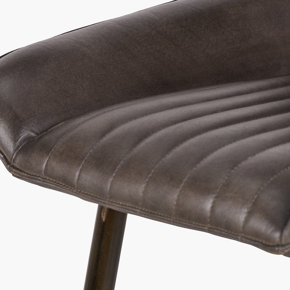 Upholstered in deep peppercorn-toned leather with ribbed cushioning and bronze metal frame, this handcrafted bar stool offers both comfort and visual impact. Shop online today at www.nobleandnook.co.uk