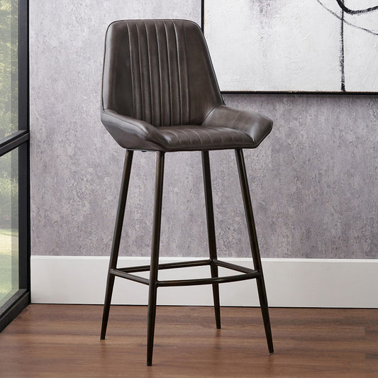 Upholstered in deep peppercorn-toned leather with ribbed cushioning and bronze metal frame, this handcrafted bar stool offers both comfort and visual impact. Shop online today at www.nobleandnook.co.uk
