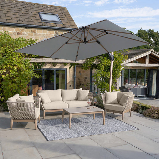 Outdoor patio set with furniture and umbrella on a stone patio.