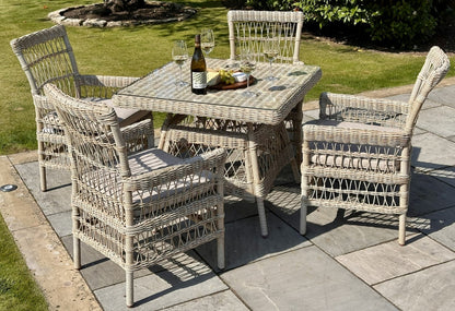 Wicker outdoor dining set with table and chairs on a patio