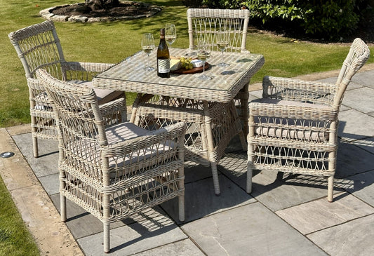 Wicker outdoor dining set with table and chairs on a patio