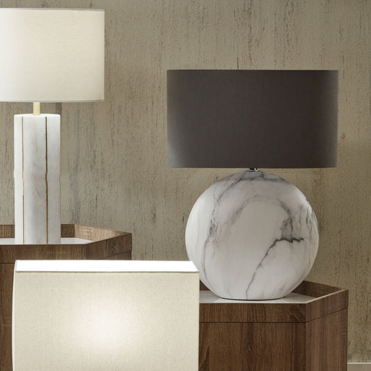 Marble-textured lamp on a wooden side table with a neutral wall background