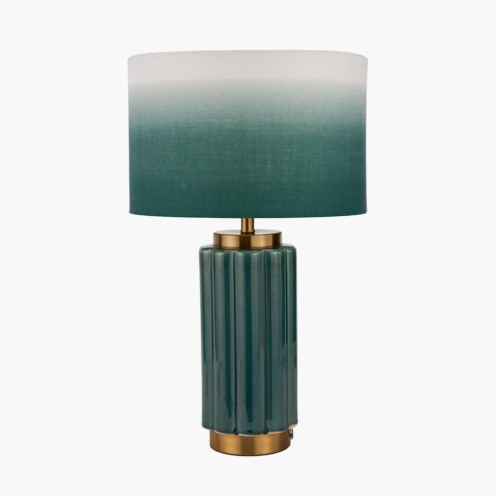 Table lamp with green gradient shade and gold base on a white background