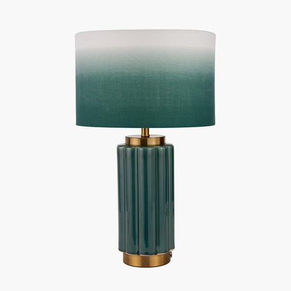 Table lamp with green gradient shade and gold base on a white background