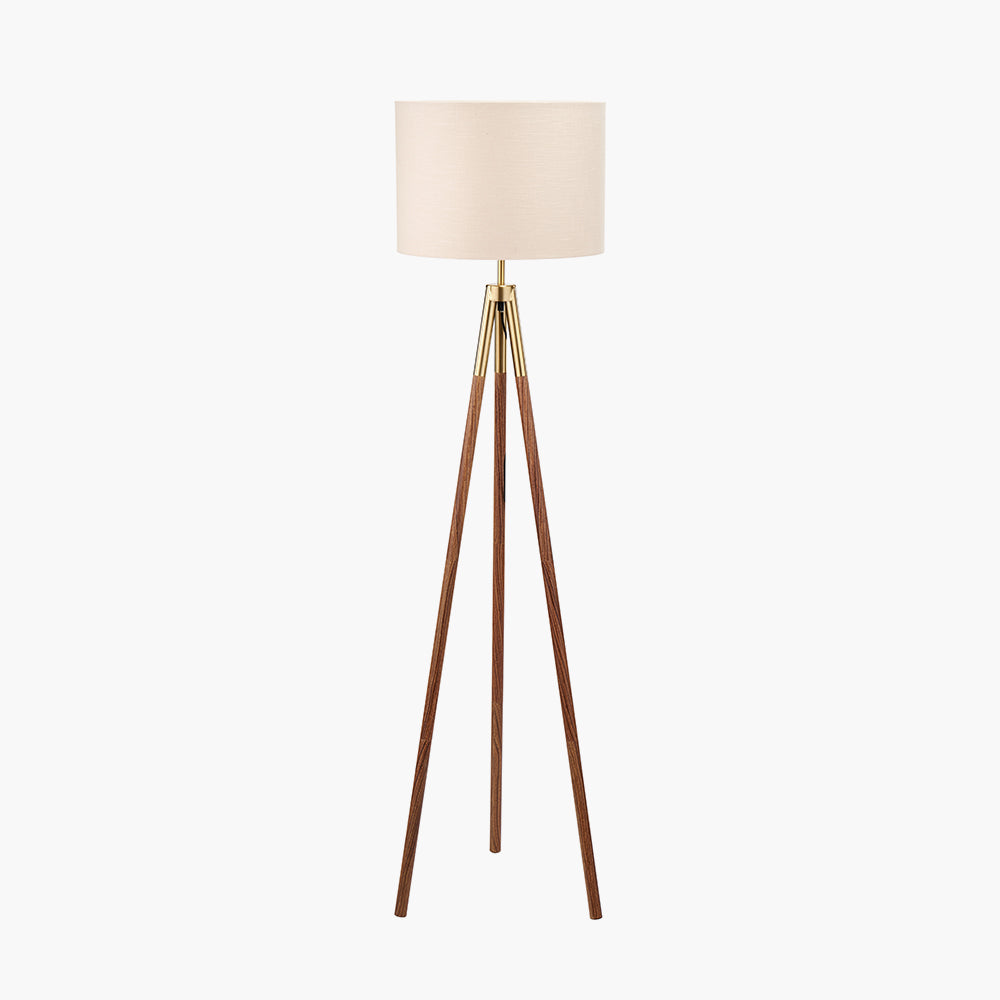 Tripod floor lamp with a beige lampshade on a white background