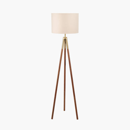 Tripod floor lamp with a beige lampshade on a white background