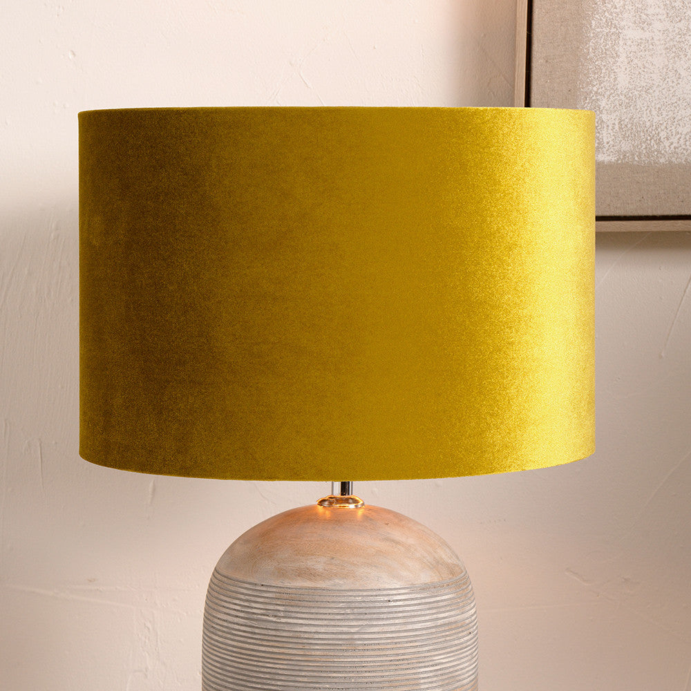 Yellow lampshade on a textured base against a neutral background