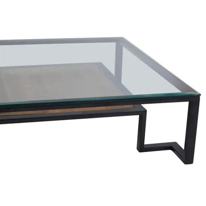Featuring a refined balance of materials, its clear glass top is perfectly framed by a black metal structure, complemented by a warm teak wood shelf below. Shop online today at www.nobleandnook.co.uk