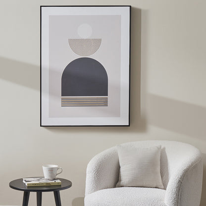 Abstract art print on a wall above a white armchair with a side table.
