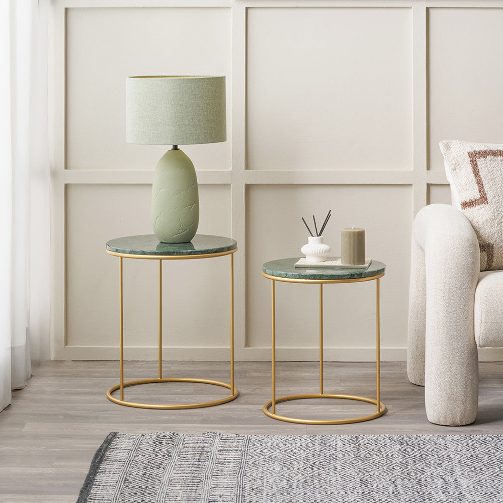 Two marble top side tables with gold metal frames in a living room setting.