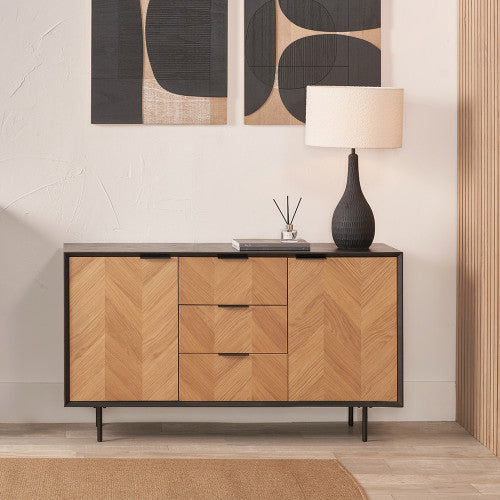 This sideboard showcases a beautiful chevron-patterned oak veneer front that pops against its sleek black wood frame. W140xD43xH80cm. Shop online today at www.nobleandnok.co.uk
