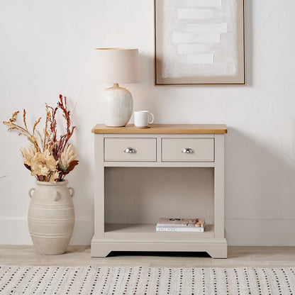 Add timeless country cottage charm to your home with the Fairford 2-Drawer Console Table. Crafted from pine wood with a parchment-white finish and oak-effect top, this elegant table offers practical storage and arrives fully assembled.