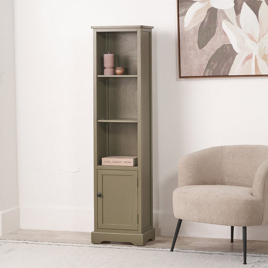 Tall green bookshelf with a beige armchair and floral artwork in a room.