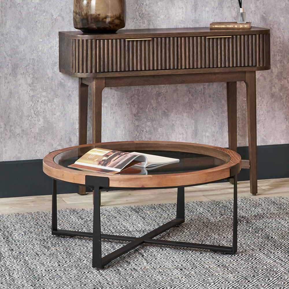 Wooden coffee table with magazine and sideboard against a gray wall.