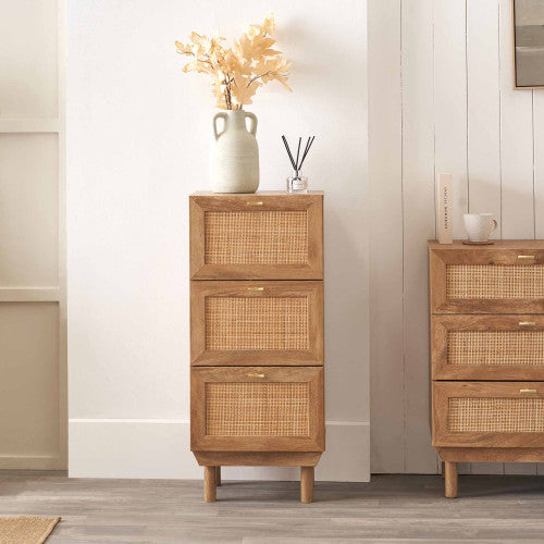 Wooden cabinet with wicker drawers against a white wall
