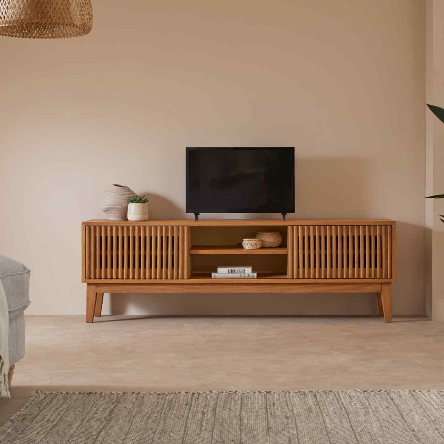 Wooden TV stand with a television in a living room setting.