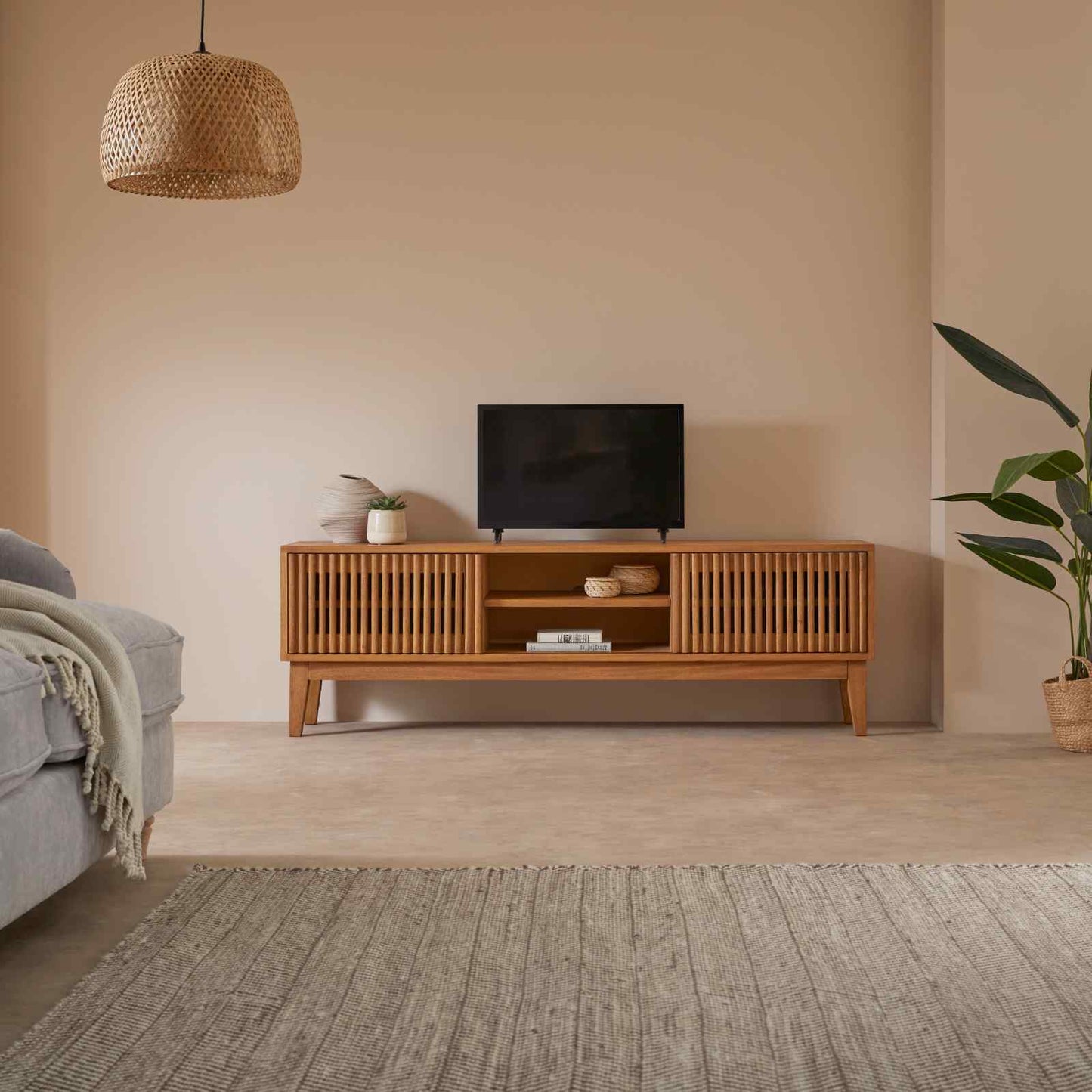 Wooden TV stand with a television in a living room setting.