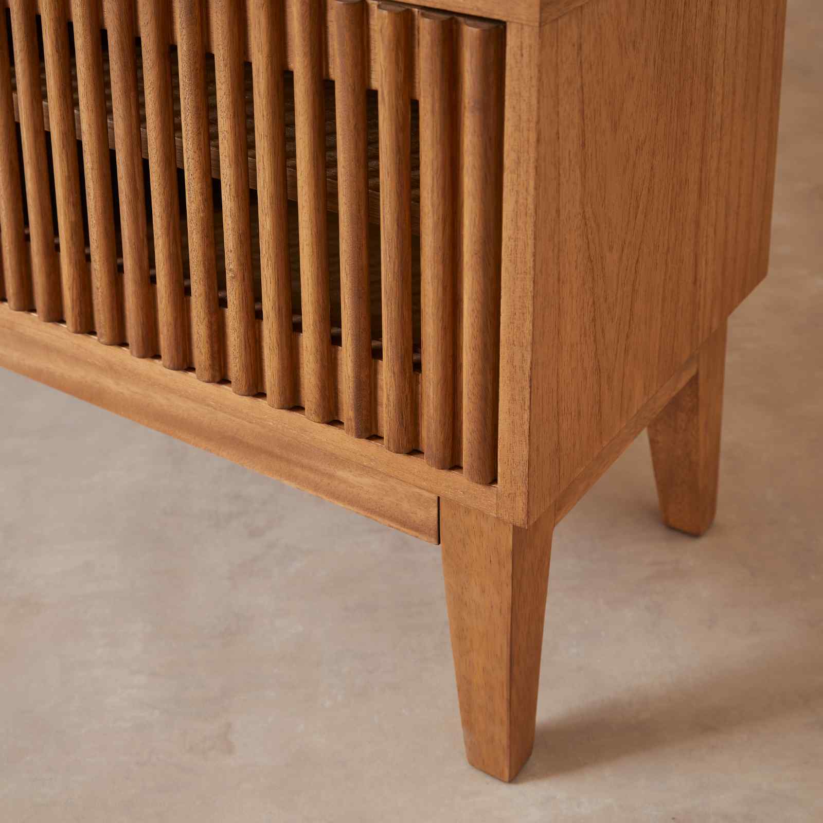 Wooden cabinet with slatted design on a beige background