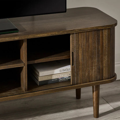 Elevate your living room with the Arya TV Media Unit in refined dark oak effect finish with sliding slatted doors. Perfect for modern homes. Shop online today at www.nobleandnook.co.uk
