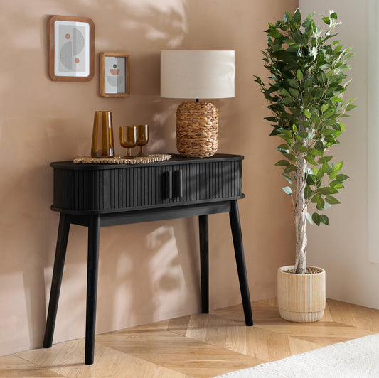 Elevate your interior with the Axel Console Table in Black. This stylish table features exquisite fluted detailing, adds depth and sophistication to any living space. Shop online today at www.nobleandnook.co.uk