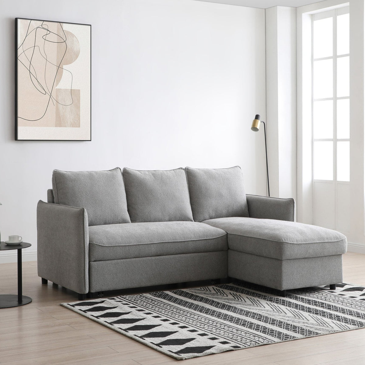 Gray sectional sofa in a modern living room with abstract art and a rug.