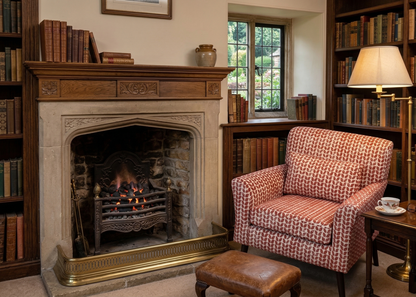 Cosy room with a fireplace, armchair, and bookshelves.