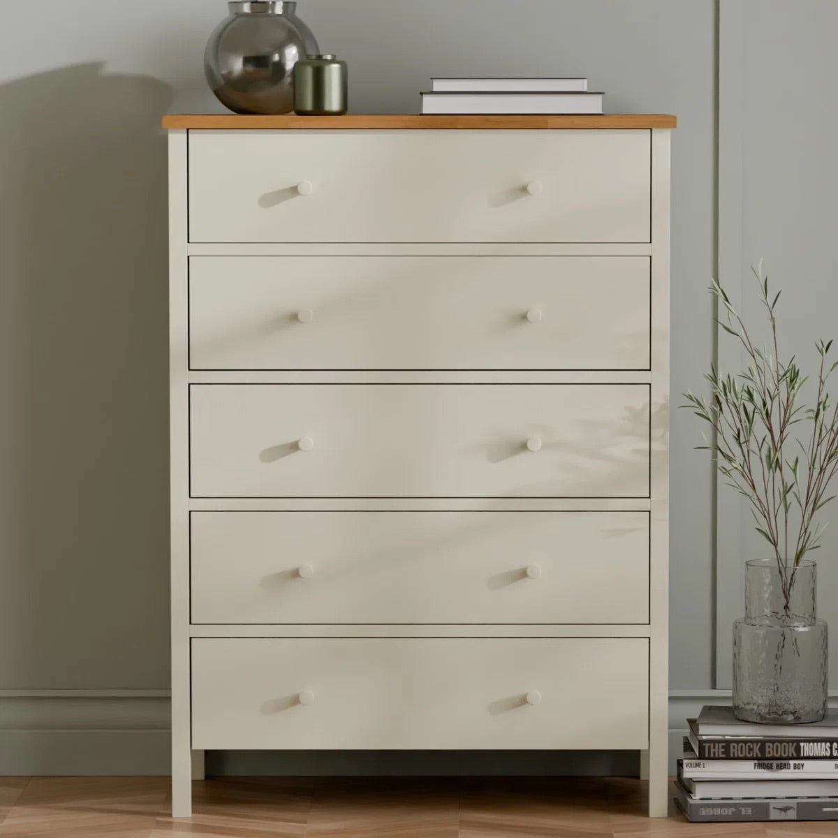 White dresser with wooden top against a neutral wall