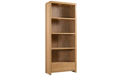 The Curve Tall Solid Oak Bookcase, a stylish and practical addition to any modern home. Its clean lines and gently curved edging bring a touch of retro charm to your living or dining space. Shop online at www.nobleandnook.co.uk