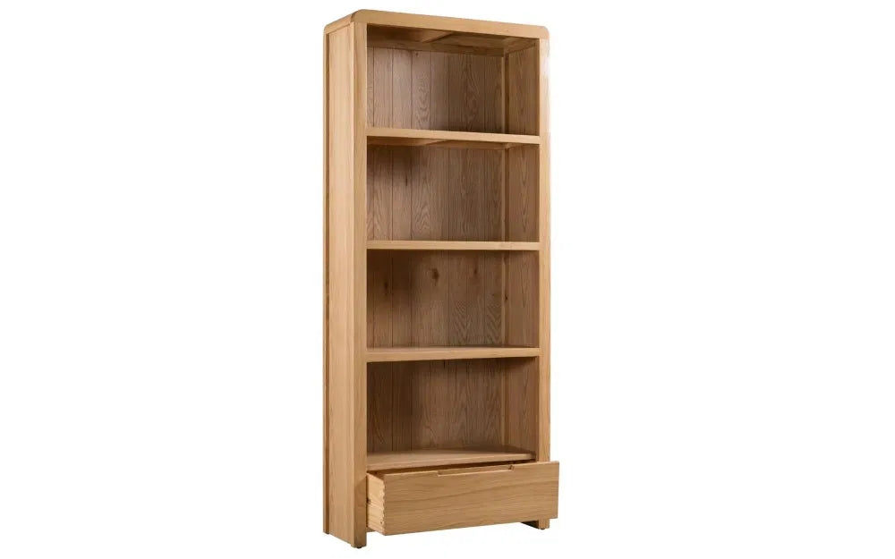 The Curve Tall Solid Oak Bookcase, a stylish and practical addition to any modern home. Its clean lines and gently curved edging bring a touch of retro charm to your living or dining space. Shop online at www.nobleandnook.co.uk