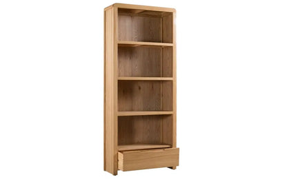 The Curve Tall Solid Oak Bookcase, a stylish and practical addition to any modern home. Its clean lines and gently curved edging bring a touch of retro charm to your living or dining space. Shop online at www.nobleandnook.co.uk