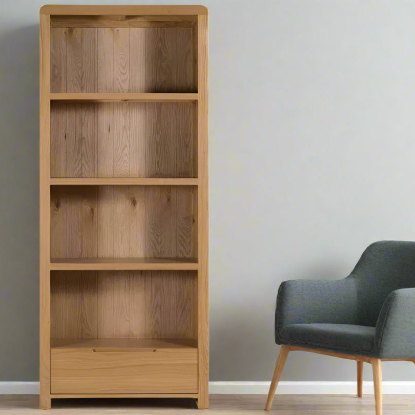 The Curve Tall Solid Oak Bookcase, a stylish and practical addition to any modern home. Its clean lines and gently curved edging bring a touch of retro charm to your living or dining space. Shop online at www.nobleandnook.co.uk