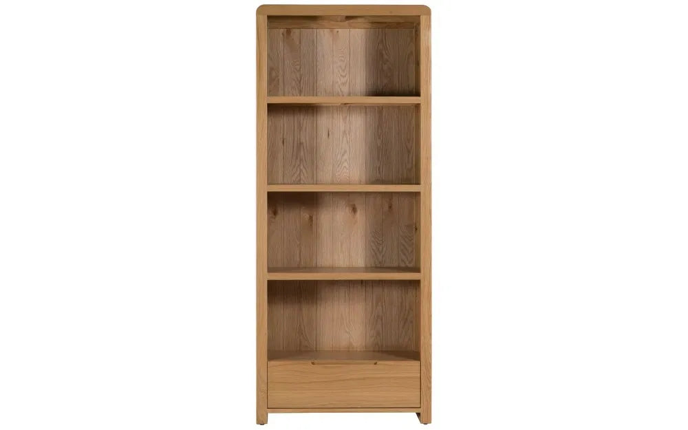 The Curve Tall Solid Oak Bookcase, a stylish and practical addition to any modern home. Its clean lines and gently curved edging bring a touch of retro charm to your living or dining space. Shop online at www.nobleandnook.co.uk