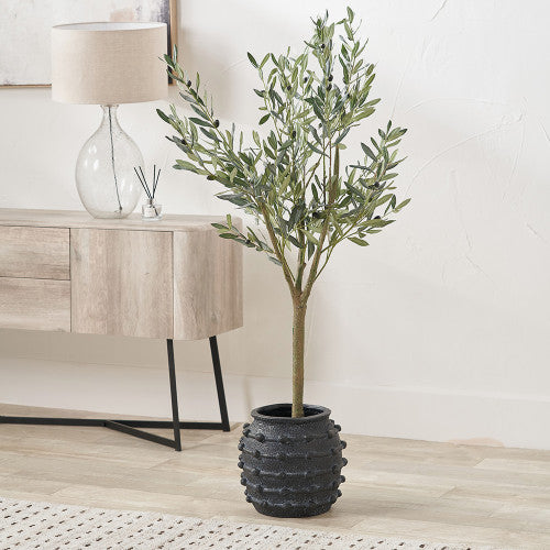 Potted artificial olive tree in a living room setting with a lamp and sideboard.