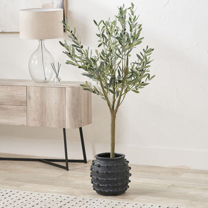Potted artificial olive tree in a living room setting with a lamp and sideboard.